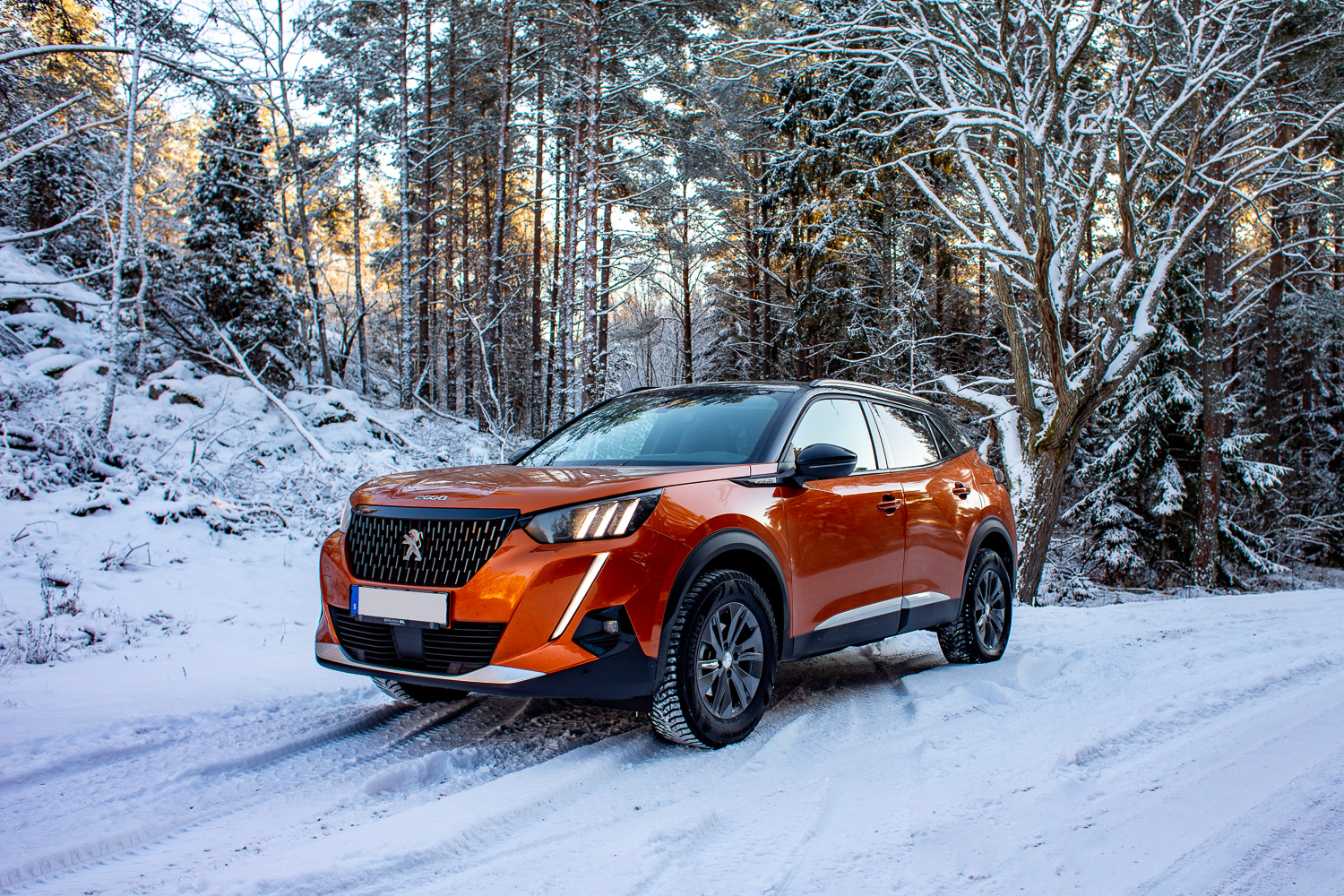 Bil, peugeot 2008 suv, på snötäckt vinterväg i skog