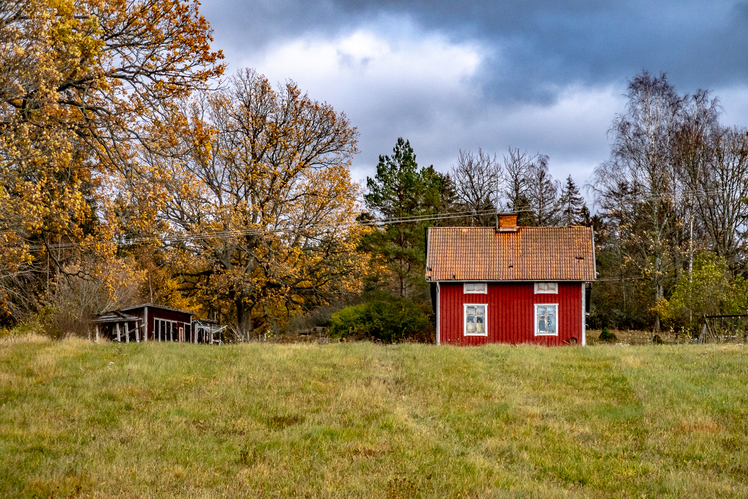 Rött litet hus med trasigt tak