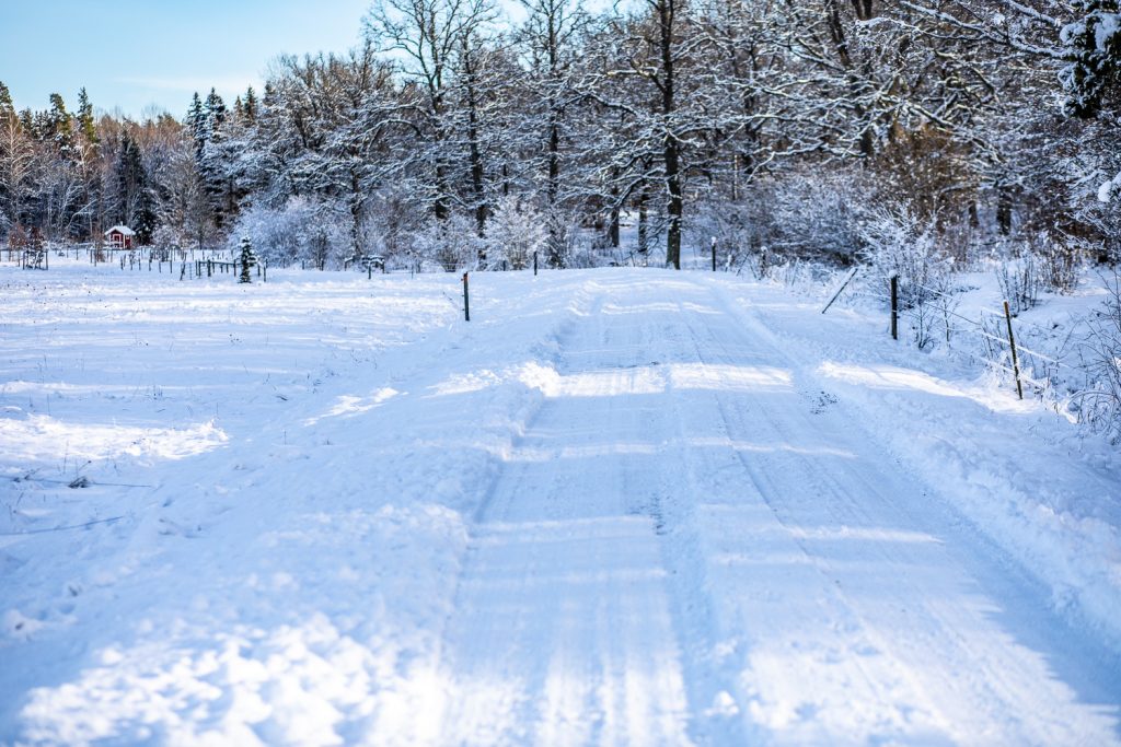 Snötäckt bilväg på väg till parkeringen vid Ullstämmaskogens naturreservat