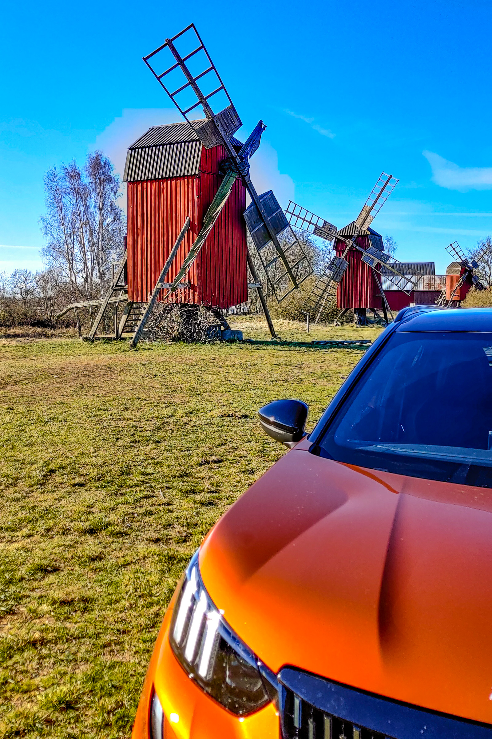 Störlinge väderkvarnar med bil i förgrunden